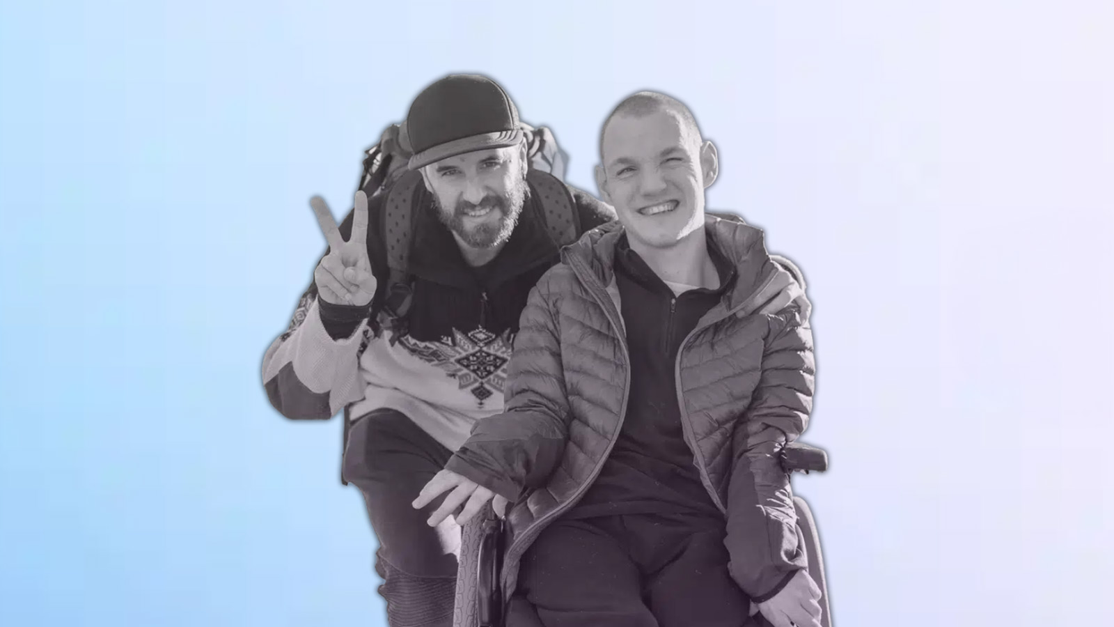 a boy in a wheel chair with a friend standing next to him.